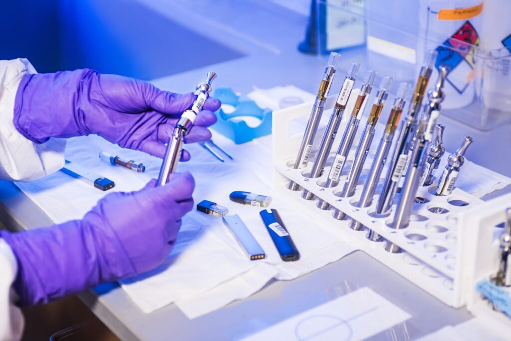 A scientist holds a vial of Casgevy gene-editing therapy in a lab with CRISPR equipment in the background.