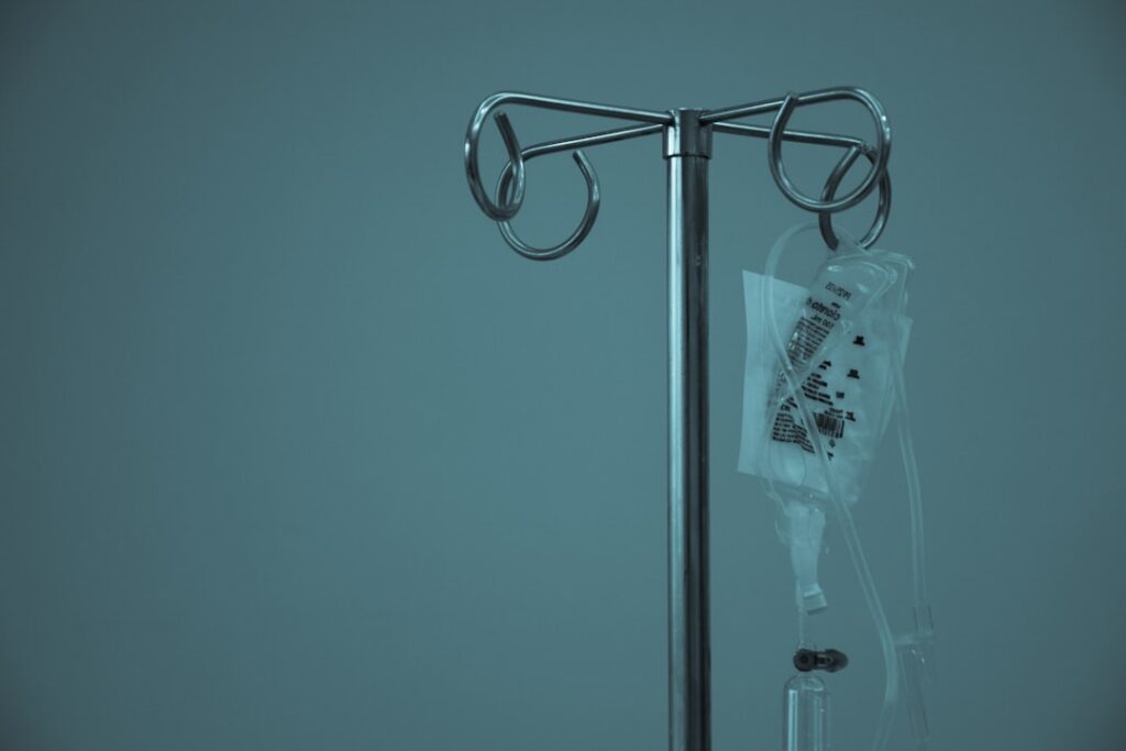 A medical professional holds an intravenous infusion bag labeled Opdualag in a clinical setting.